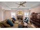 Cozy living room with hardwood floors, brick fireplace, and a tray ceiling with fan, creating an inviting atmosphere at 3264 Salem Cove Se Trl, Conyers, GA 30013