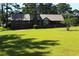 Wide view of the back of a brick house with a metal roof, fence, and large grassy yard at 5225 Kings Hwy, Douglasville, GA 30135