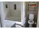 Modern bathroom with subway tile, soaking tub, and shelving above toilet at 5225 Kings Hwy, Douglasville, GA 30135