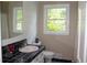 Bathroom features a black tiled counter, white cabinets, and a window with natural light at 5225 Kings Hwy, Douglasville, GA 30135