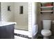 Modern bathroom featuring white subway tile, soaking tub, and shelving above toilet at 5225 Kings Hwy, Douglasville, GA 30135