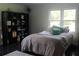 Bedroom with wood flooring, windows, black shelving, and a comfortable bed at 5225 Kings Hwy, Douglasville, GA 30135