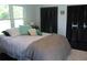 Cozy bedroom with a comfortable bed, dark wood floors, and black louvered closet doors at 5225 Kings Hwy, Douglasville, GA 30135