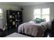 Bedroom with wood flooring, windows, black shelving, and a comfortable bed at 5225 Kings Hwy, Douglasville, GA 30135