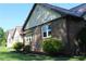 Close view of a brick house featuring a metal roof and manicured green shrubs at 5225 Kings Hwy, Douglasville, GA 30135