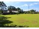 Spacious front yard showing a house with a metal roof and lush green lawn under a partly cloudy blue sky at 5225 Kings Hwy, Douglasville, GA 30135