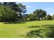 Green lawn with mature trees that provide ample shade and enhance the property's appeal under a sunny sky at 5225 Kings Hwy, Douglasville, GA 30135