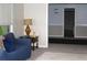 Relaxing living room with a comfortable blue sofa, side table with lamp, and open doorway at 5225 Kings Hwy, Douglasville, GA 30135