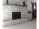 Stone fireplace with a dark wood mantle in a cozy living space with vacuum cleaner at 5225 Kings Hwy, Douglasville, GA 30135