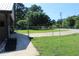 Side yard featuring a chain-link fence, lush green lawn, and a paved walkway leading to the house at 5225 Kings Hwy, Douglasville, GA 30135