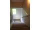 Carpeted stairway with a window at the end provides natural light to the upper level at 5225 Kings Hwy, Douglasville, GA 30135