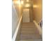 Well-lit stairway features carpeted steps and white painted banisters leading to a closed door at 5225 Kings Hwy, Douglasville, GA 30135