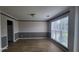Spacious dining room featuring a bright window, wooden flooring, and neutral-colored walls at 3219 Roundfield Cir, Duluth, GA 30096