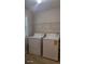 Functional laundry area featuring a standard washer and dryer with overhead shelving at 3219 Roundfield Cir, Duluth, GA 30096