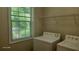 Cozy laundry area with stacked washer and dryer, plus a window for natural light at 3219 Roundfield Cir, Duluth, GA 30096