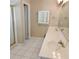 Bathroom with double sinks, white tile flooring, and a glass door shower at 5035 Harbor Ridge Dr, Buford, GA 30518