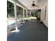 This covered patio features a ceiling fan and overlooks a backyard with a stone retaining wall and wooden fence at 5035 Harbor Ridge Dr, Buford, GA 30518