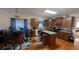 Well-lit kitchen features an island with granite countertops, brown cabinets, and wood floors at 2435 Hickory Station Cir, Snellville, GA 30078