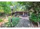 Spacious backyard featuring lush landscaping, a stone walkway, manicured lawn, and a patio for relaxation at 2994 Baker Ridge Nw Dr, Atlanta, GA 30318