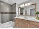 Bathroom with tub and shower combination, decorative tile, and wood vanity with a large framed mirror at 2994 Baker Ridge Nw Dr, Atlanta, GA 30318