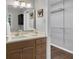 Bathroom with a wood vanity, white countertop, square mirror, decorative wall art, and view into walk-in closet at 2994 Baker Ridge Nw Dr, Atlanta, GA 30318