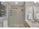 Bathroom features a tiled shower with glass door, window, and modern fixtures over a white vanity top at 2994 Baker Ridge Nw Dr, Atlanta, GA 30318