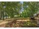 Backyard view from the deck with mature trees, stairs, and natural landscaping at 6674 Cowan Mill Rd, Winston, GA 30187