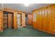 Finished basement area with wood-paneled walls, green carpet, built-in closet, and partially-renovated bathroom at 6674 Cowan Mill Rd, Winston, GA 30187