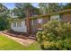 The home features a brick facade, a decorative front door, and mature landscaping along a walkway at 6674 Cowan Mill Rd, Winston, GA 30187