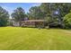 A ranch-style home features lush landscaping, a covered porch, and a convenient carport on a spacious lawn at 6674 Cowan Mill Rd, Winston, GA 30187