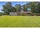 Charming single-story home features a well-manicured lawn, mature trees, and a convenient carport at 6674 Cowan Mill Rd, Winston, GA 30187