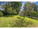 View of the sloped backyard featuring a scattering of trees and a distant view of the property at 6674 Cowan Mill Rd, Winston, GA 30187
