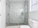Modern bathroom featuring a glass-enclosed shower with white tiles and a pebble floor, offering a sleek and contemporary design at 83 Ormond Se St, Atlanta, GA 30315