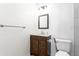 Bathroom with dark wood vanity, granite countertop, framed mirror, and modern lighting, alongside white fixtures and hardware at 83 Ormond Se St, Atlanta, GA 30315