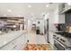 Open kitchen with sleek white cabinets, stainless steel appliances, and an adjacent living area at 2110 Augusta Se Dr # 204, Marietta, GA 30067