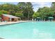 Community swimming pool with chaise lounges and blue umbrellas with a brick pool house at 383 Ralph Mcgill Ne Blvd # J, Atlanta, GA 30312