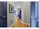 Hallway showing wooden floors, art and closet with louvred blue doors, leading to an open living space at 400 W Peachtree Nw St # 3711, Atlanta, GA 30308