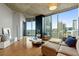 Living room showcasing floor-to-ceiling windows with city views, wood floors, and modern furniture at 400 W Peachtree Nw St # 3711, Atlanta, GA 30308