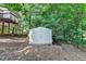A level, wooded backyard features a shed for extra storage at 1990 Holly Cove Rd, Cumming, GA 30040