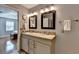 Neutral bathroom featuring a double vanity, wood-framed mirrors, and hardwood floors beyond at 1990 Holly Cove Rd, Cumming, GA 30040