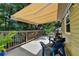 The deck features an awning for shade, overlooking a private wooded yard with seating and lighting at 1990 Holly Cove Rd, Cumming, GA 30040