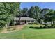 Charming one-story home featuring a well-manicured lawn and mature trees at 1990 Holly Cove Rd, Cumming, GA 30040
