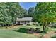Landscaped front yard with mature trees and a winding walkway to the charming home at 1990 Holly Cove Rd, Cumming, GA 30040
