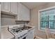 A bright kitchenette with white cabinets and appliances and a view to the outside at 1990 Holly Cove Rd, Cumming, GA 30040