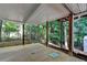 This covered patio with wood supports has a concrete floor and views of the wooded yard at 1990 Holly Cove Rd, Cumming, GA 30040