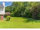 Expansive backyard featuring a lush lawn and surrounded by mature trees at 2325 Sailor Ln, Suwanee, GA 30024