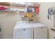 Functional laundry room with side-by-side washer and dryer and storage shelves at 2325 Sailor Ln, Suwanee, GA 30024