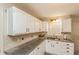 Bright kitchen featuring white cabinets, granite countertops, and stainless sink at 7490 Hunters Ridge Dr, Douglasville, GA 30134