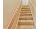 Carpeted staircase with wooden handrail, providing a safe and comfortable transition between floors at 7490 Hunters Ridge Dr, Douglasville, GA 30134