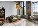 Bright living room featuring an exposed brick wall, large windows, and stylish lighting fixtures at 170 Boulevard Se # 221E, Atlanta, GA 30312